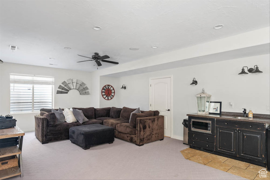Living area featuring light carpet, a ceiling fan, and recessed lighting