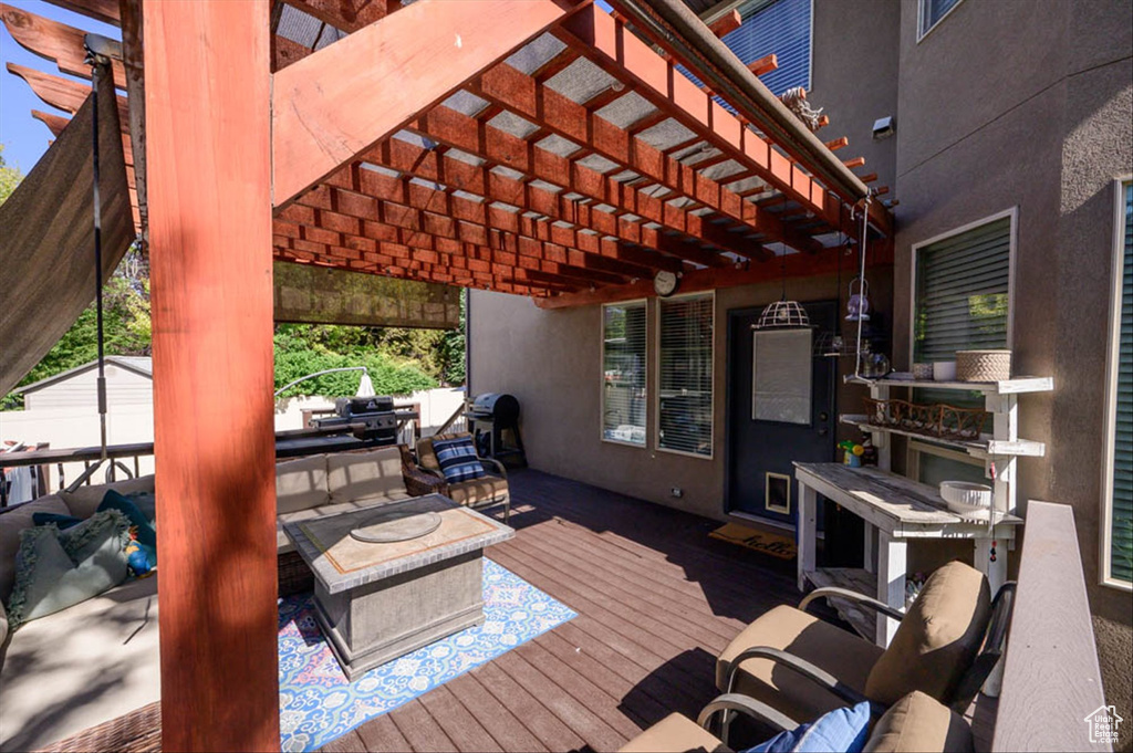 Wooden deck featuring a pergola, outdoor lounge area, and a storage shed