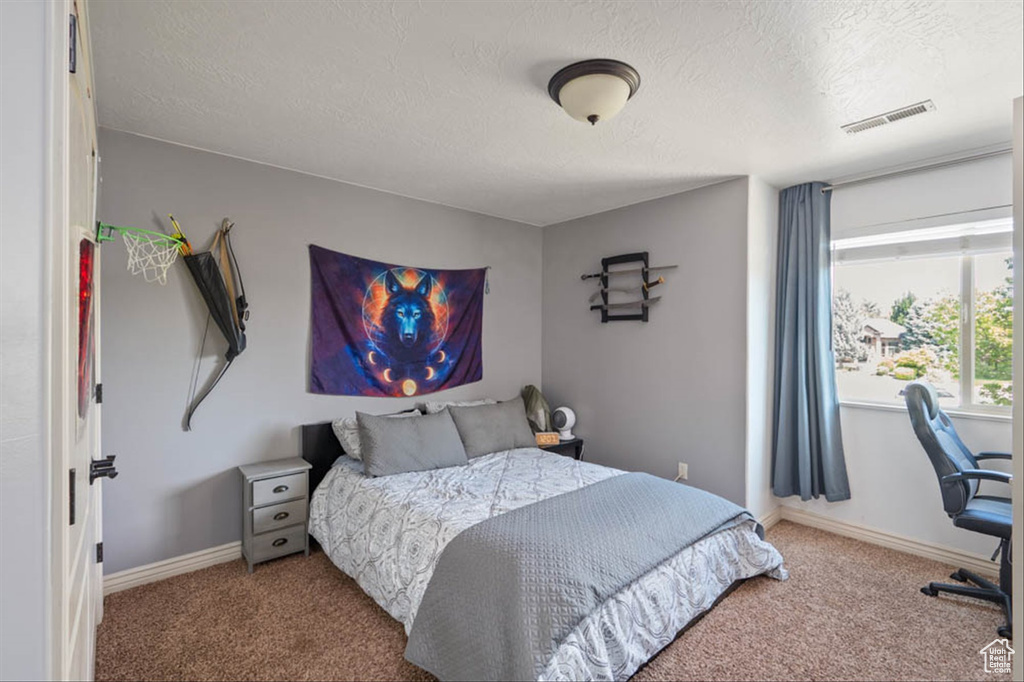 Carpeted bedroom featuring a textured ceiling