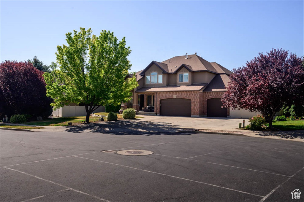 View of front of property with brick siding, an attached garage, and concrete driveway