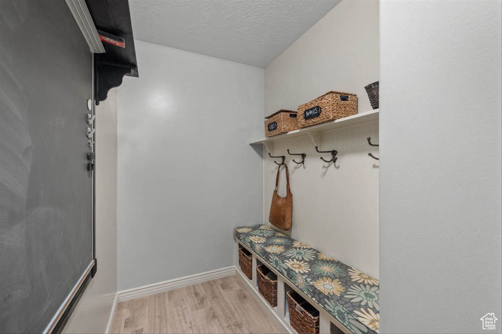 Mudroom featuring light wood-type flooring and a textured ceiling