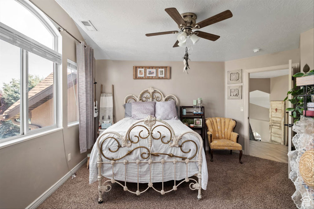 Bedroom with carpet, ceiling fan, and a textured ceiling