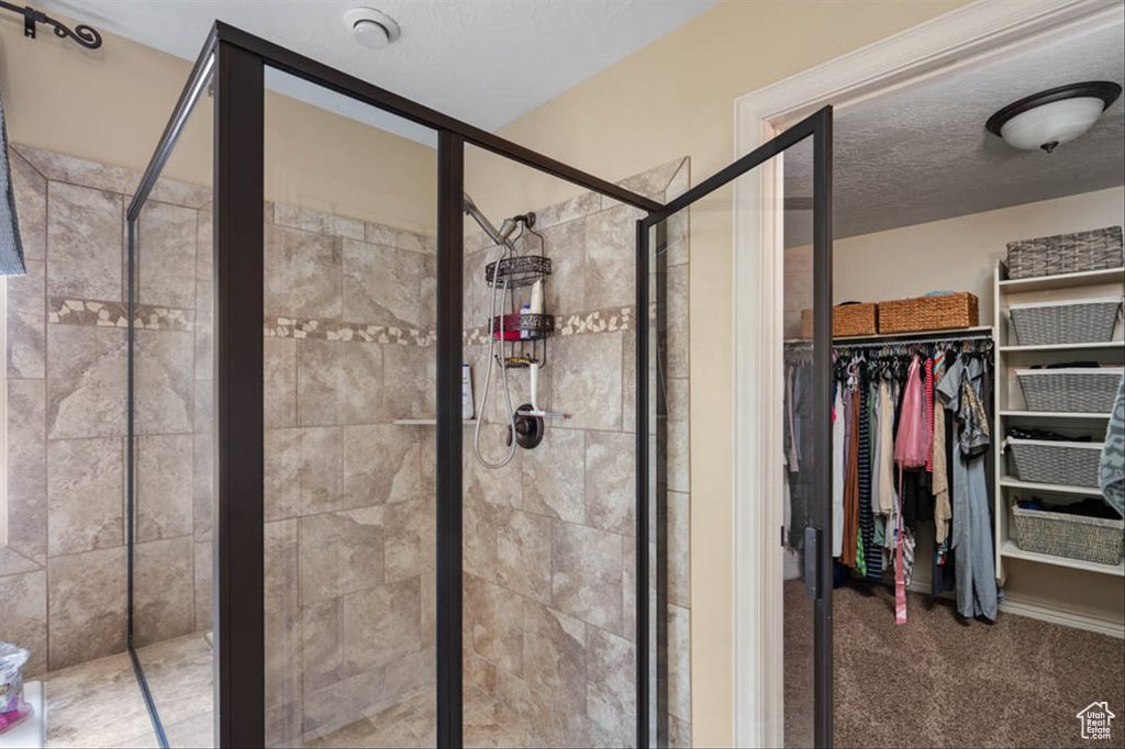 Full bath with a stall shower and a walk in closet