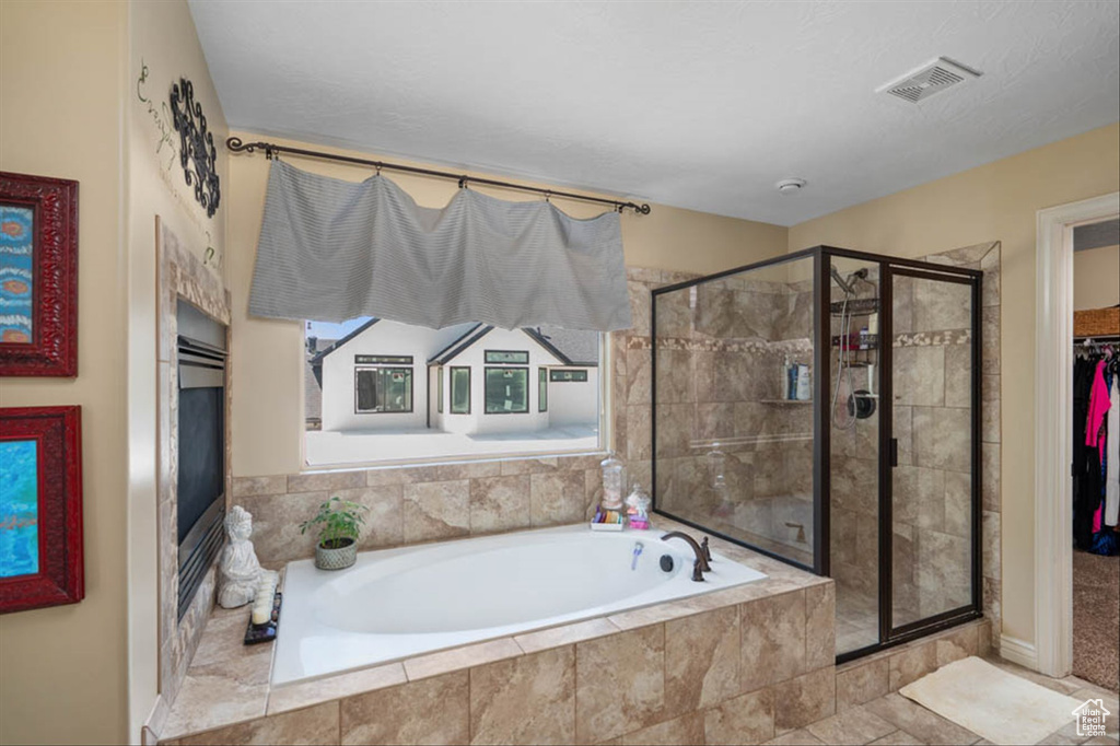 Full bath featuring a bath, a stall shower, and a spacious closet