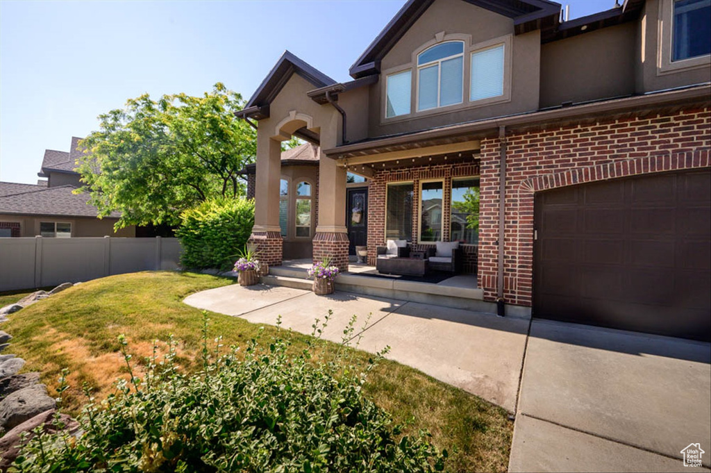Back of house with stucco siding, brick siding, and an outdoor hangout area