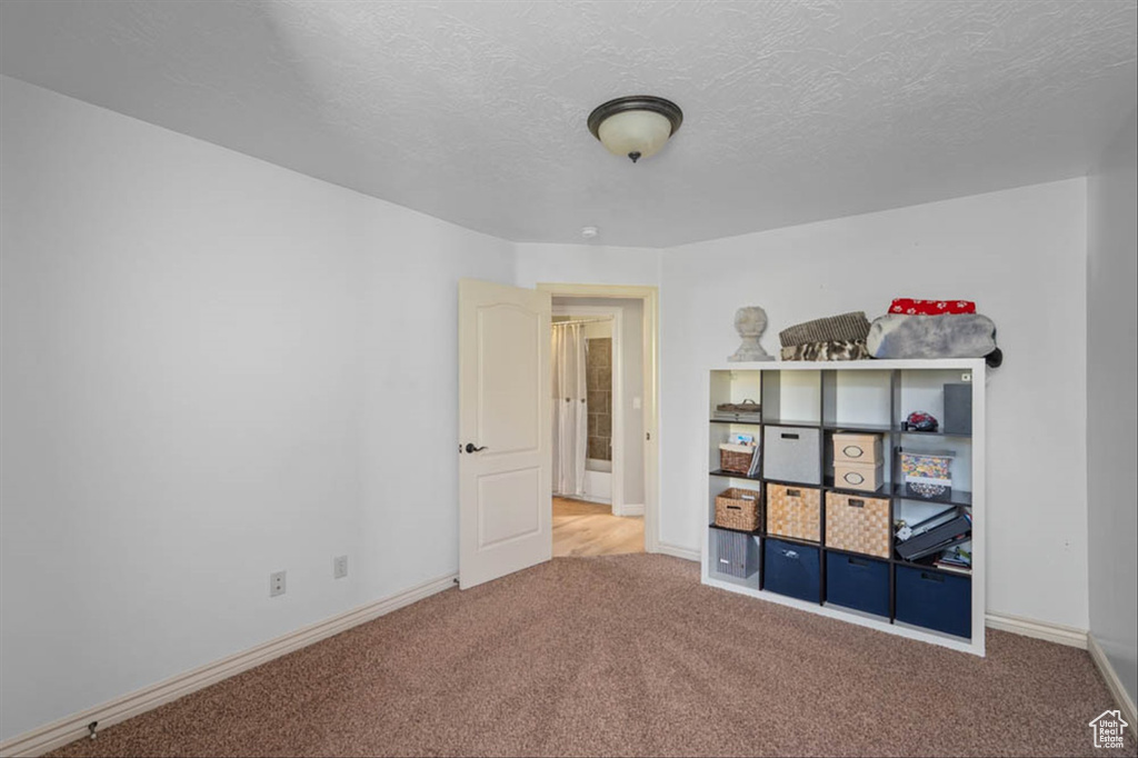 Unfurnished bedroom with carpet flooring and a textured ceiling