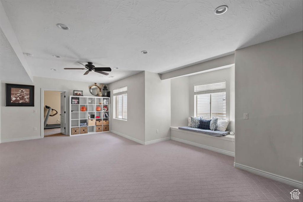 Empty room featuring carpet flooring, a ceiling fan, and a textured ceiling