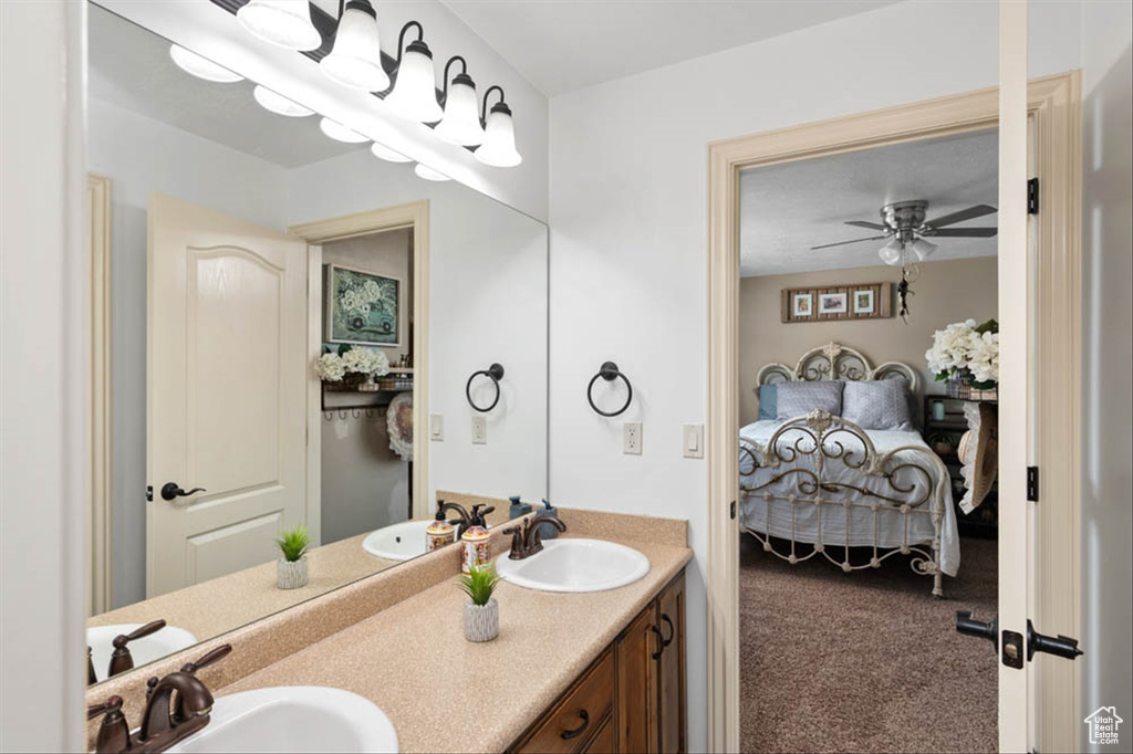 Ensuite bathroom featuring double vanity and a ceiling fan