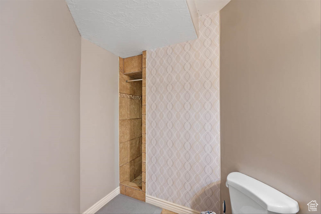 Full bathroom with toilet and tiled shower