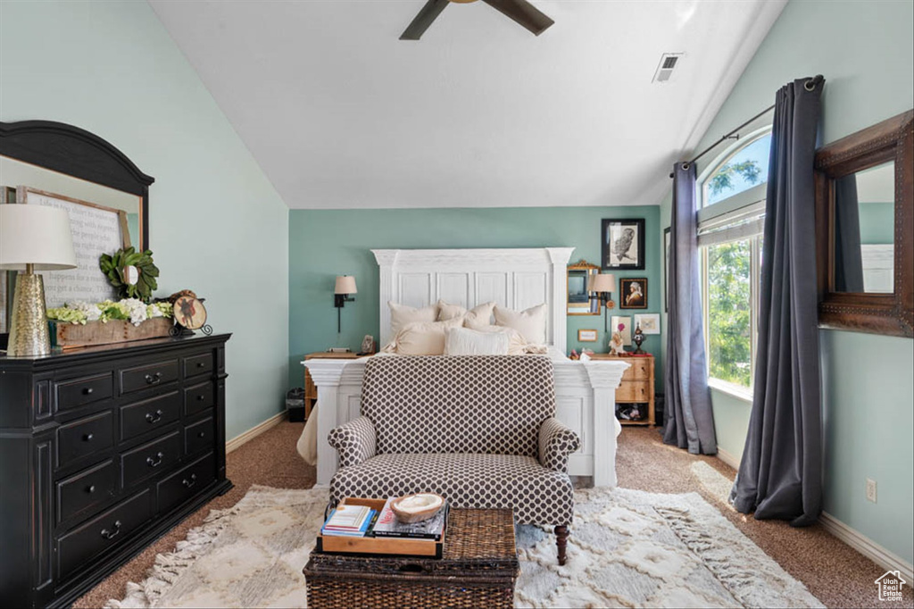 Carpeted bedroom featuring vaulted ceiling and a ceiling fan