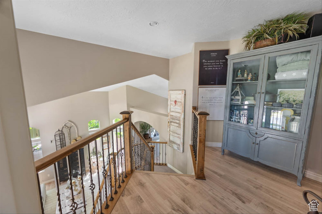 Hallway featuring an upstairs landing and light wood-style flooring
