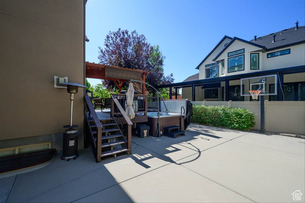 View of patio / terrace with a hot tub and a deck