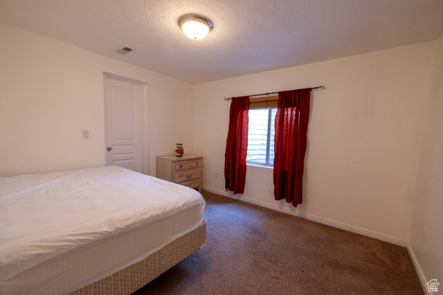 Bedroom featuring carpet floors and a textured ceiling