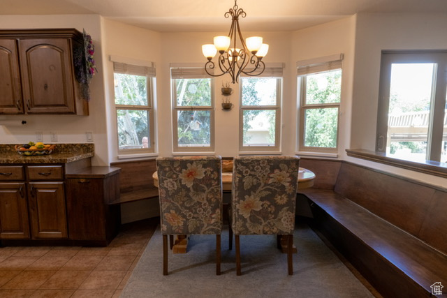 Dining room featuring a chandelier, light tile patterned flooring, and breakfast area