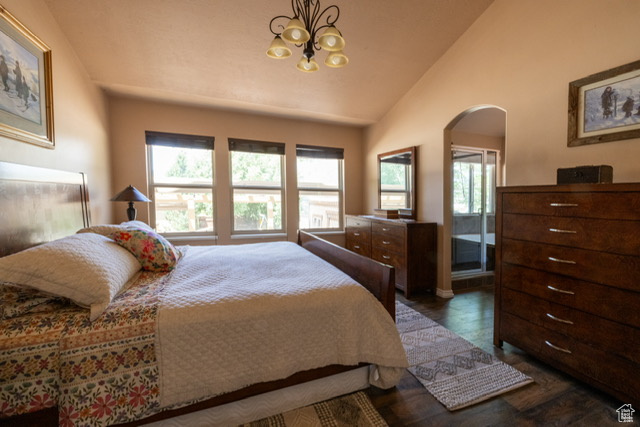 Bedroom featuring arched walkways, vaulted ceiling, a chandelier, and dark wood finished floors