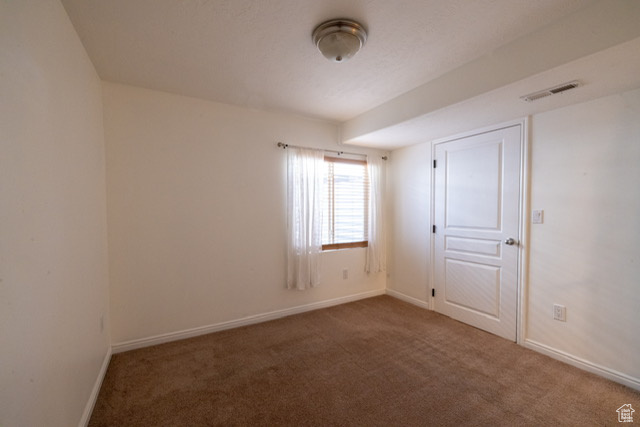 Carpeted spare room with baseboards