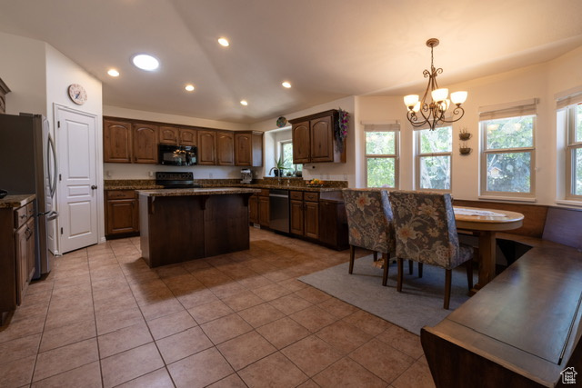 Kitchen featuring appliances with stainless steel finishes, a chandelier, recessed lighting, plenty of natural light, and a center island