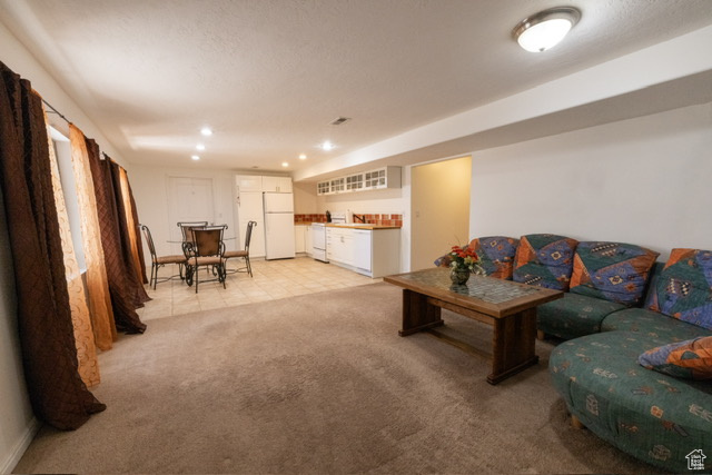 Living room with light colored carpet, recessed lighting, and bar