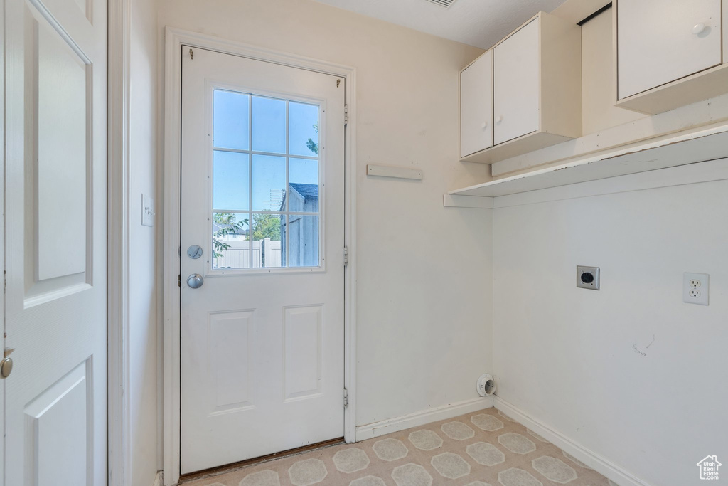 Laundry room with hookup for an electric dryer and cabinet space