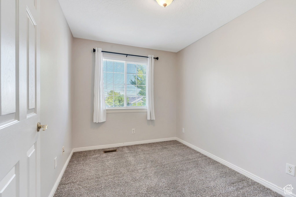 Unfurnished room with carpet flooring and baseboards
