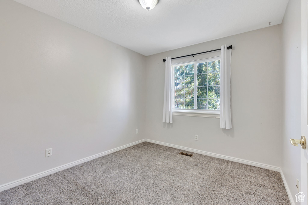 Empty room featuring carpet flooring and baseboards