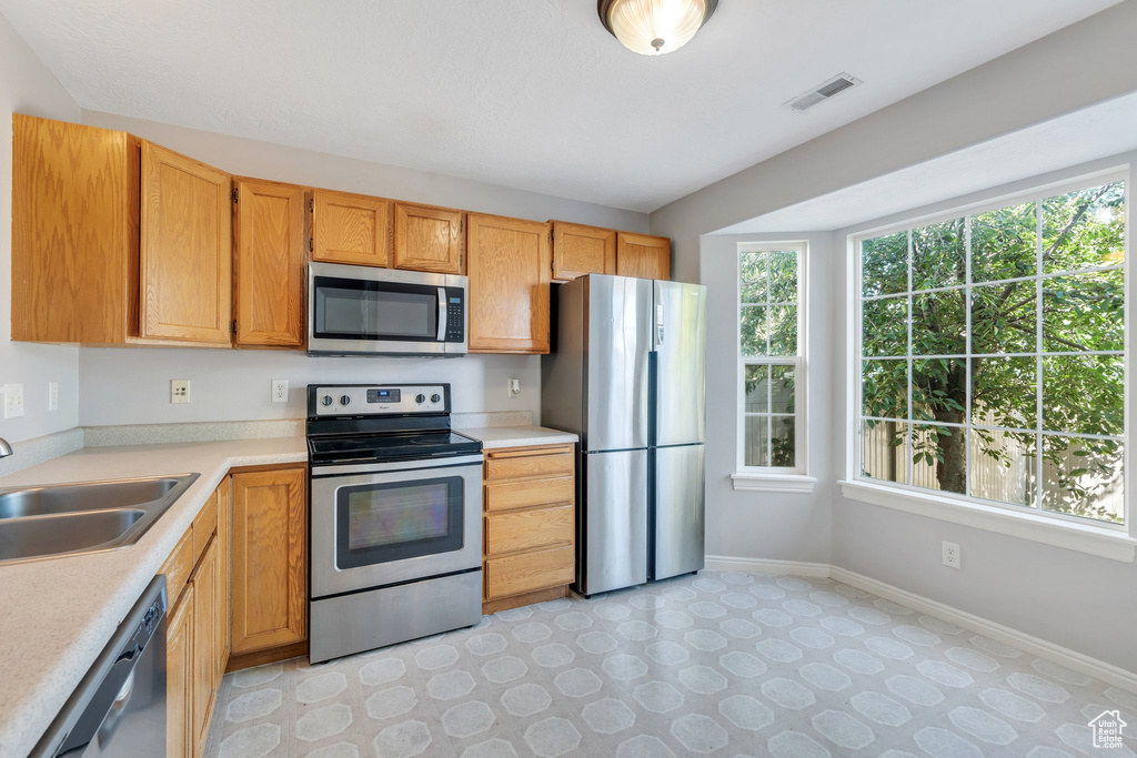 Kitchen featuring appliances with stainless steel finishes, plenty of natural light, and light countertops