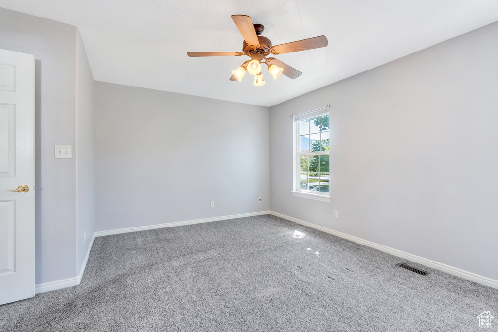 Unfurnished room with carpet and a ceiling fan