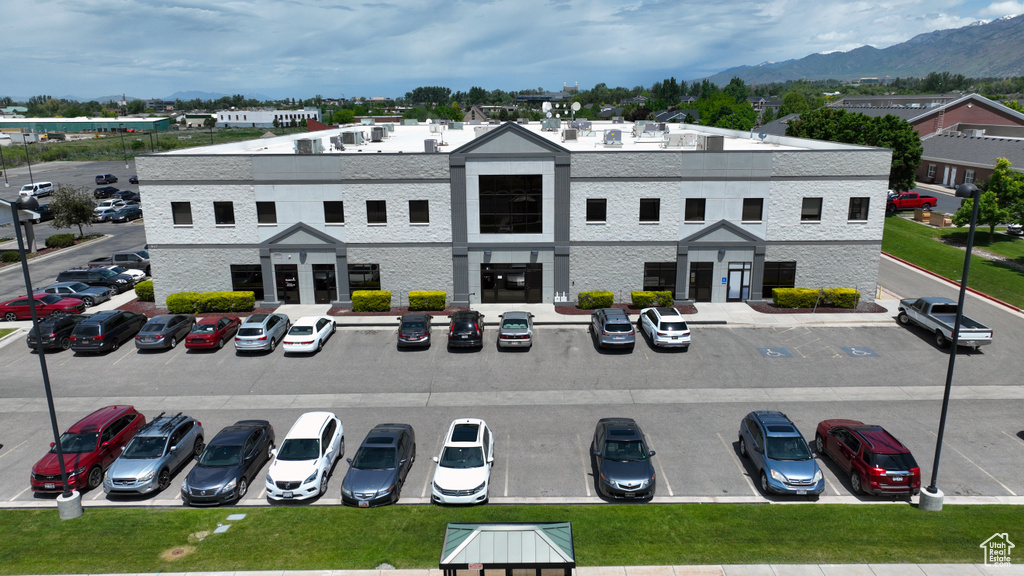 View of building exterior featuring uncovered parking and a mountain view