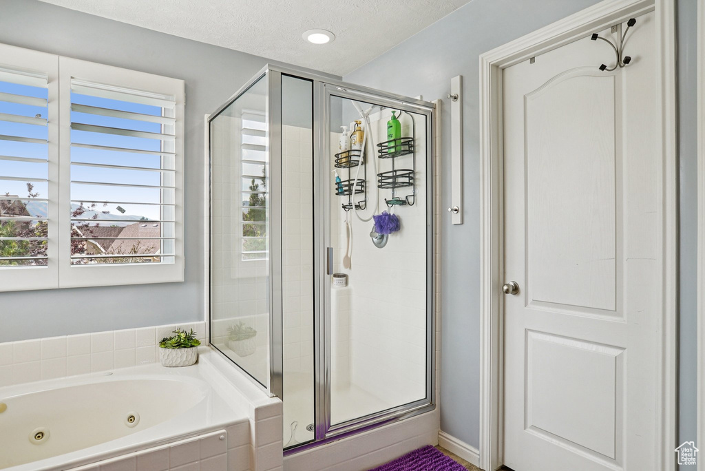 Full bathroom with a shower stall, a jetted tub, and recessed lighting