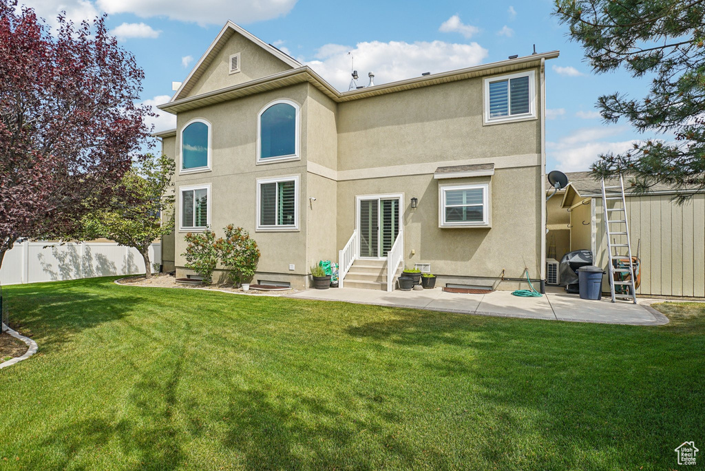 Back of property with entry steps, a patio area, and stucco siding