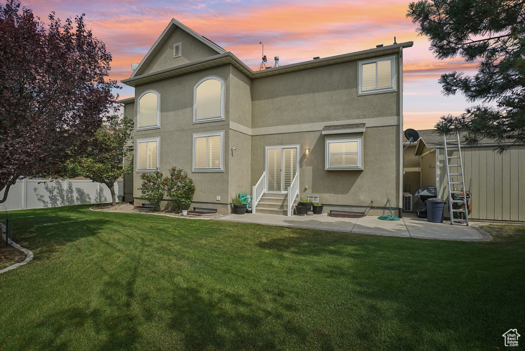 Rear view of property featuring entry steps, stucco siding, and a patio area