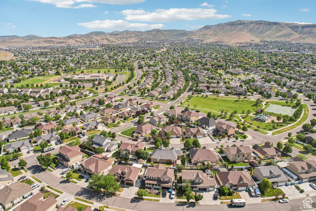 Aerial view of property and surrounding area with a mountain backdrop and nearby suburban area