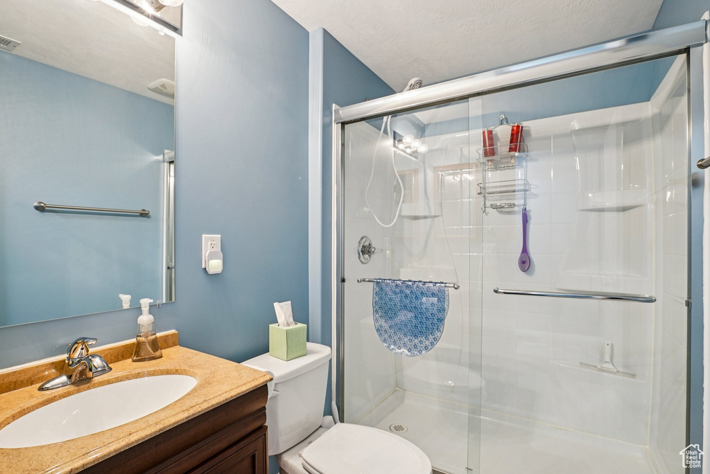 Full bath with a shower stall and vanity