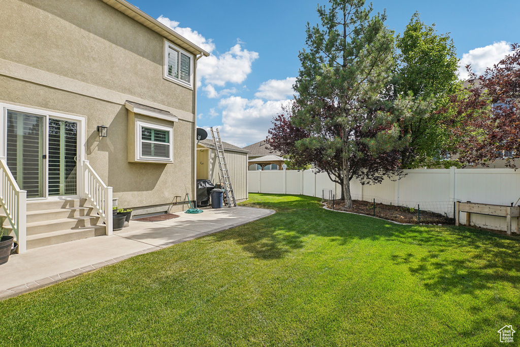 Fenced backyard with entry steps and a patio area