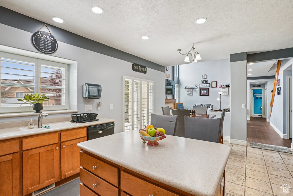 Kitchen featuring dishwasher, light countertops, plenty of natural light, brown cabinets, and recessed lighting