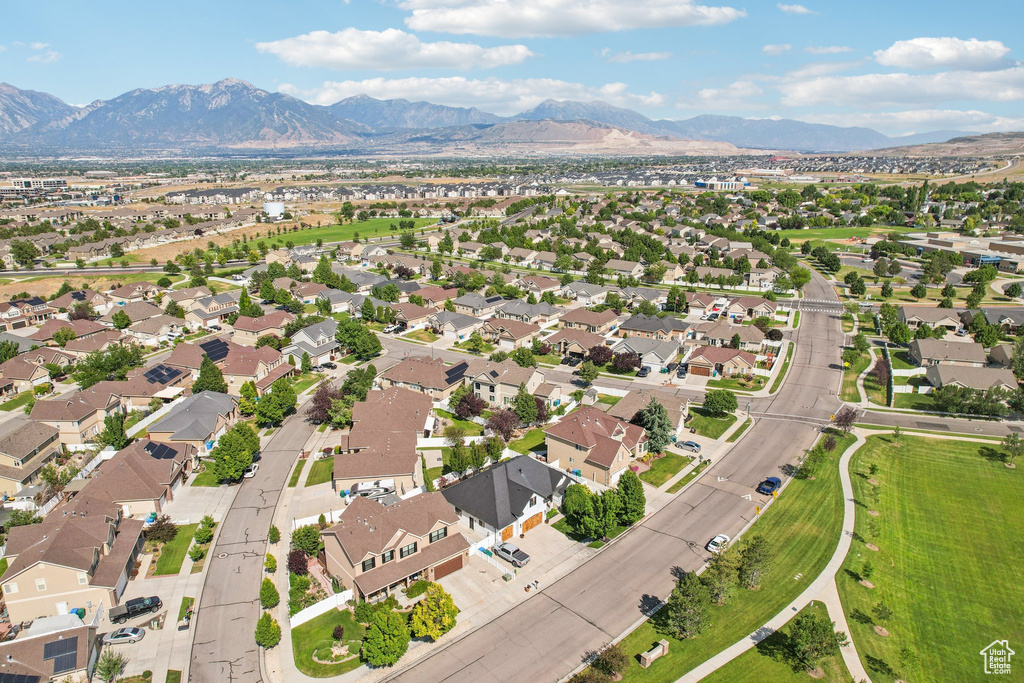 Aerial view of property and surrounding area with a mountain backdrop and nearby suburban area