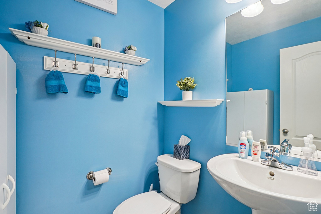 Half bath featuring a sink and toilet