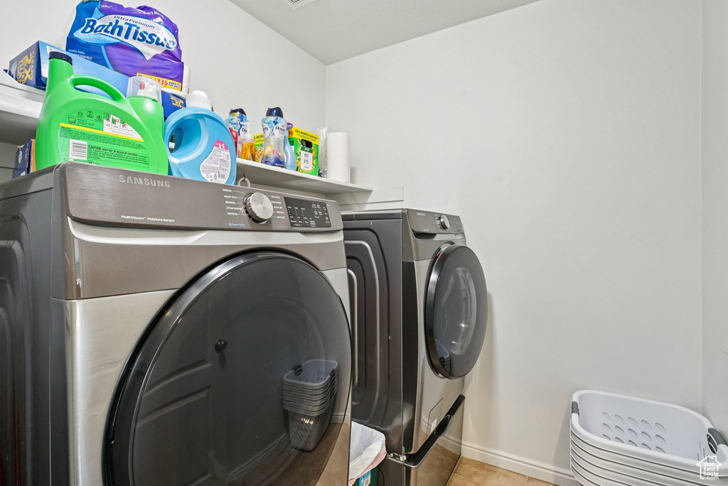Laundry room featuring washing machine and clothes dryer and tile patterned flooring