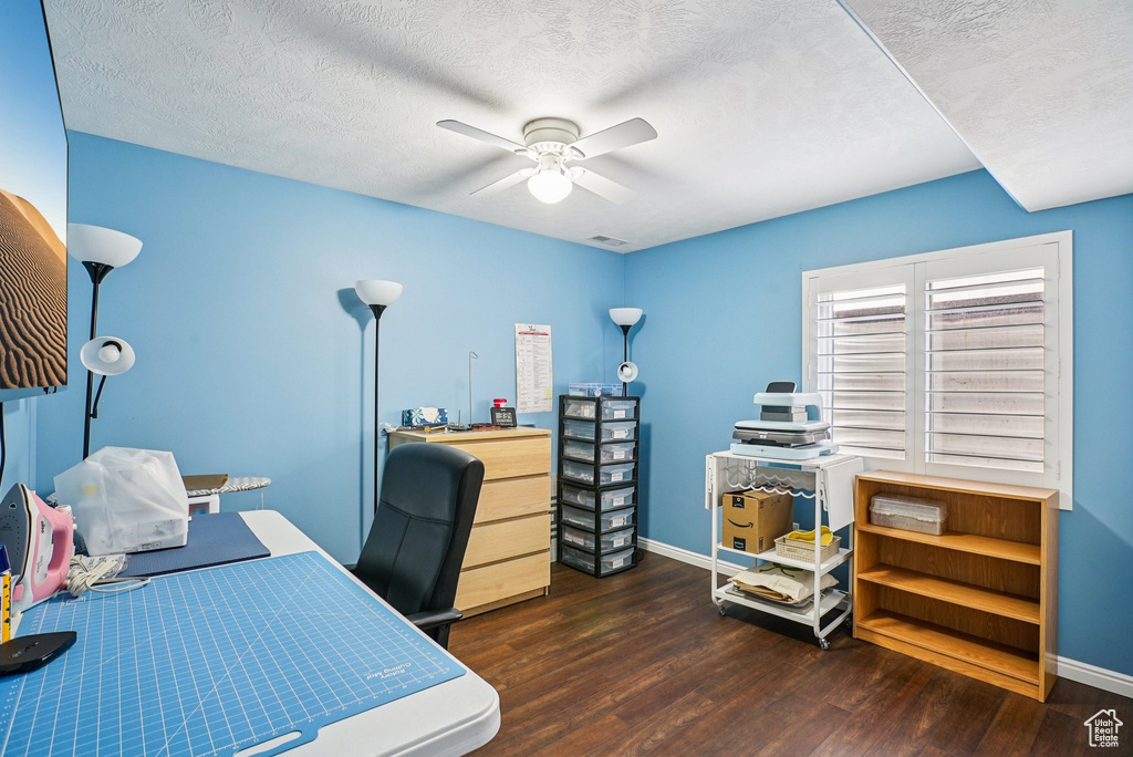 Office space featuring a ceiling fan, wood finished floors, and a textured ceiling