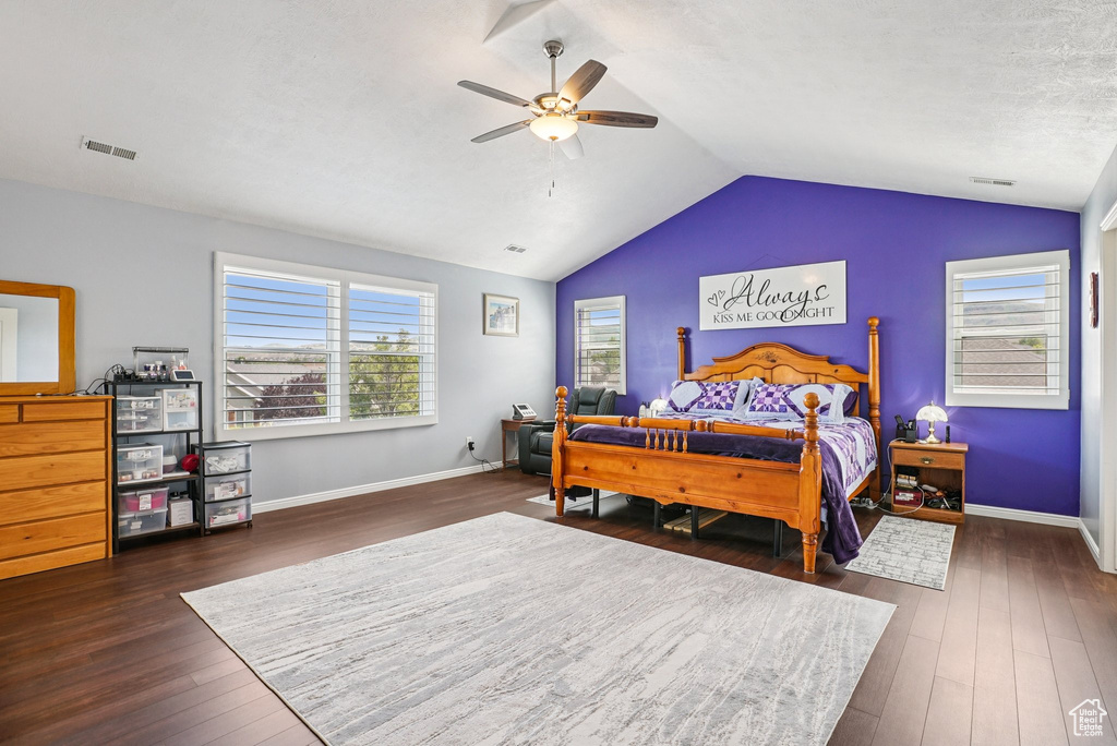 Bedroom with dark wood-style floors, vaulted ceiling, and ceiling fan
