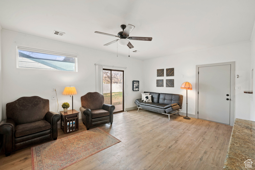 Living area with light wood finished floors and ceiling fan