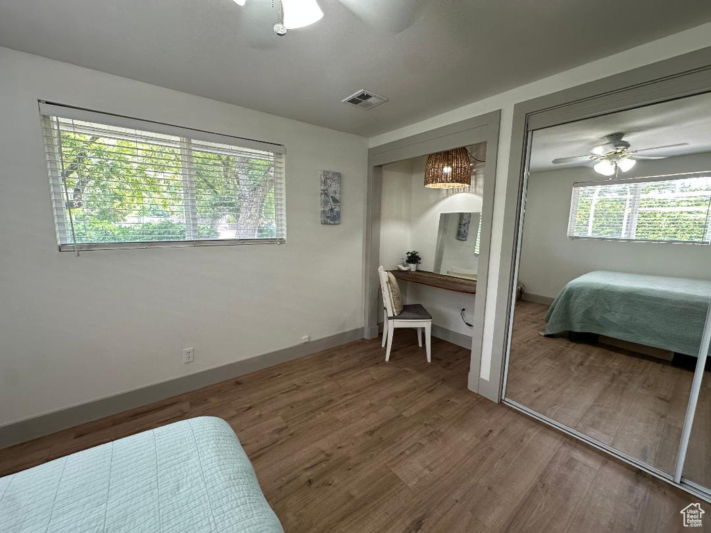Bedroom featuring two closets, wood finished floors, and a ceiling fan
