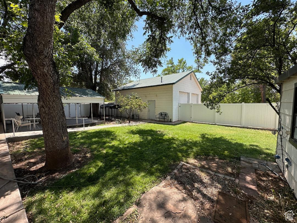 Fenced backyard featuring a patio and an outbuilding