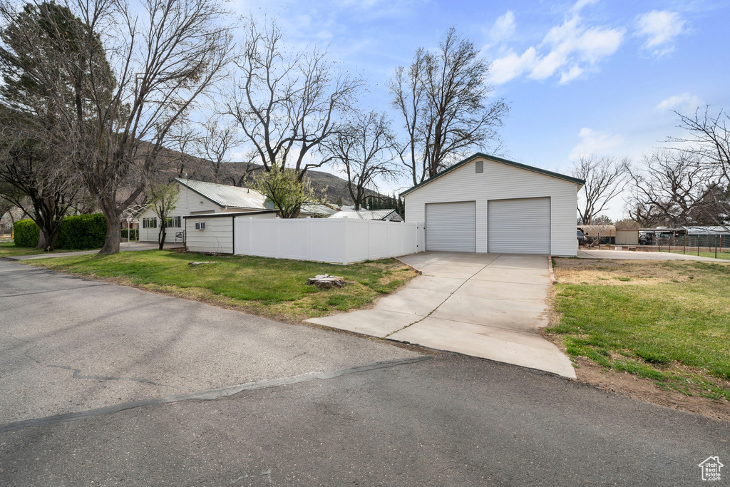View of property exterior with an outdoor structure and a detached garage