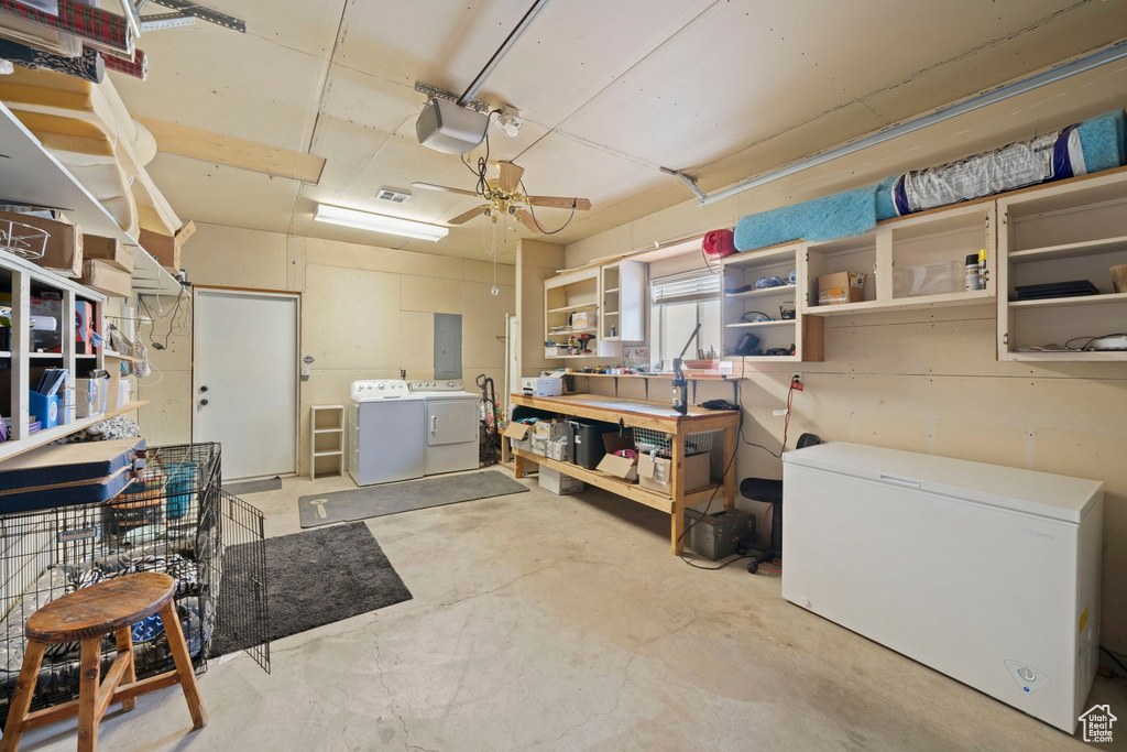 Basement with washing machine and dryer, refrigerator, electric panel, ceiling fan, and a workshop area