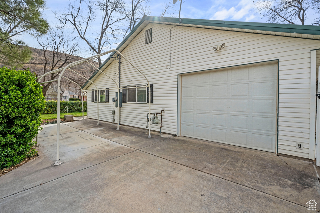 View of property exterior with concrete driveway