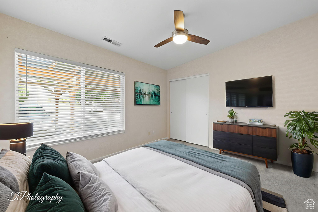 Bedroom with lofted ceiling, carpet floors, a closet, and ceiling fan
