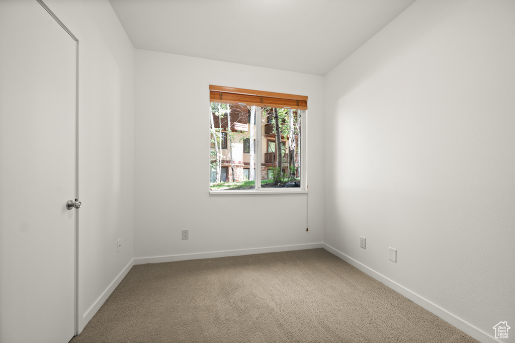 Carpeted empty room with baseboards