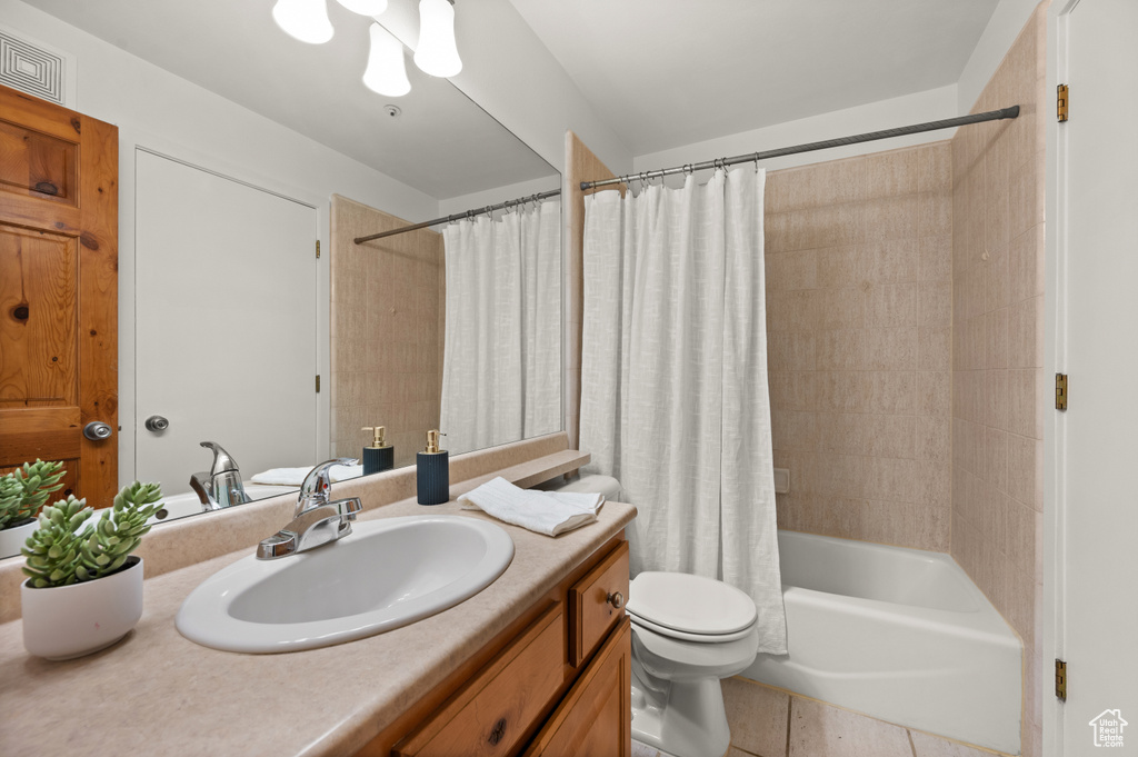 Full bathroom featuring vanity, shower / bath combination with curtain, and tile patterned floors