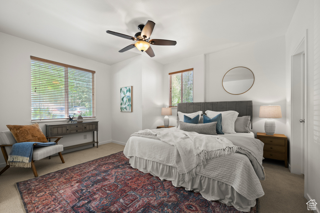 Carpeted bedroom featuring a ceiling fan and baseboards